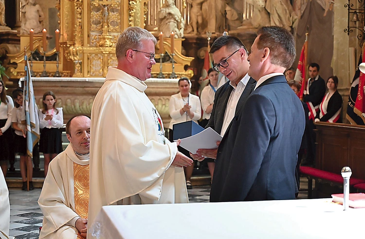 Odznakę wręczyli księdzu burmistrz Piotr Bujak i przewodniczący rady miejskiej Jerzy Kunert. 