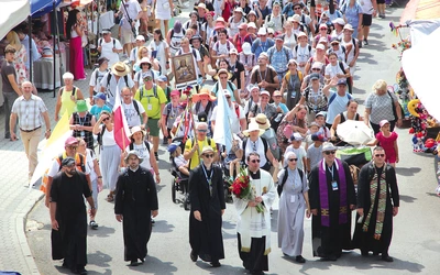 Wejście brzesko-bocheńskiej grupy. Przewodnik ks. Marcin Natonek niesie dla Maryi bukiet czerwonych róż i jedną złotą.