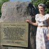 Grażyna Wosińska przy pomniku poświęconym ofiarom stalinowskiego terroru  po wydarzeniach z 17 lipca 1949 r.