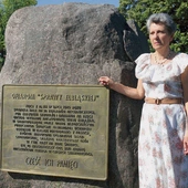 Grażyna Wosińska przy pomniku poświęconym ofiarom stalinowskiego terroru  po wydarzeniach z 17 lipca 1949 r.