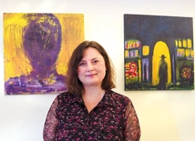 Agnieszka Paluch obok obrazów „Spotkanie Nikodema z Jezusem”  oraz „Autoportret”. 