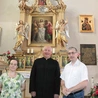 Proboszcz wspólnoty ks. Józef Milan i jej historycy – dr Barbara Hryszko i prof. Rafał Hryszko – przed ołtarzem patrona.
