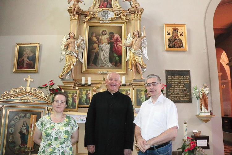 Proboszcz wspólnoty ks. Józef Milan i jej historycy – dr Barbara Hryszko i prof. Rafał Hryszko – przed ołtarzem patrona.