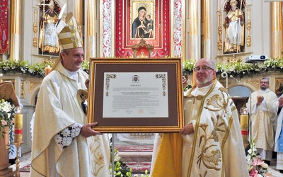 Ks. Zbigniew Jurasz i bp Roman Pindel z aktem dla świątyni.