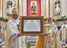 Ks. Zbigniew Jurasz i bp Roman Pindel z aktem dla świątyni.