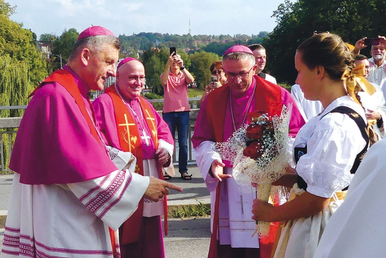 Biskupi  (od prawej) Roman Pindel, Piotr Greger i Martin David podczas powitania na przeprawie.