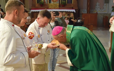 Biskup Solarczyk całuje chleb w radomskiej katedrze.
