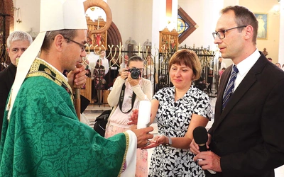 Obrzęd przekazania  odpowiedzialności nowym parom rejonowym poprzez podarowanie świecy.