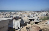 Wysiedlone rodziny palestyńskie przebywają w obozie dla uchodźców w mieście Gaza, w pobliżu nadmorskiej drogi