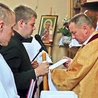 Obrzęd przyjęcia przyrzeczenia zakonnego. Kandydat trzyma świecę i wypowiada słowa ślubowania.