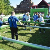 Uczestnicy zawodów grają w piłkę nożną w dmuchanym basenie.