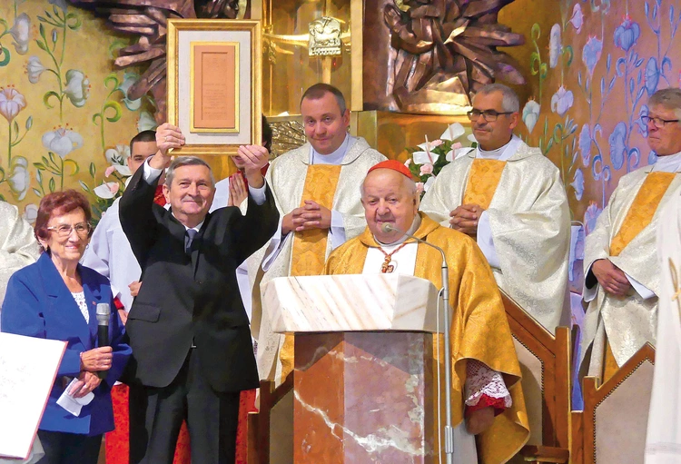 Parafianie prezentujący cegłę wyjętą  z drzwi rzymskiej bazyliki  – znak jedności Złotych Łanów z Kościołem powszechnym.