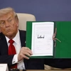 Donald Trump pokazuje podpisany w Sharm el-Sheikh dokument