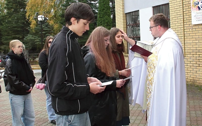 Ks. Pawlak  kreśli krzyż na czołach oazowiczów.