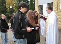 Ks. Pawlak  kreśli krzyż na czołach oazowiczów.