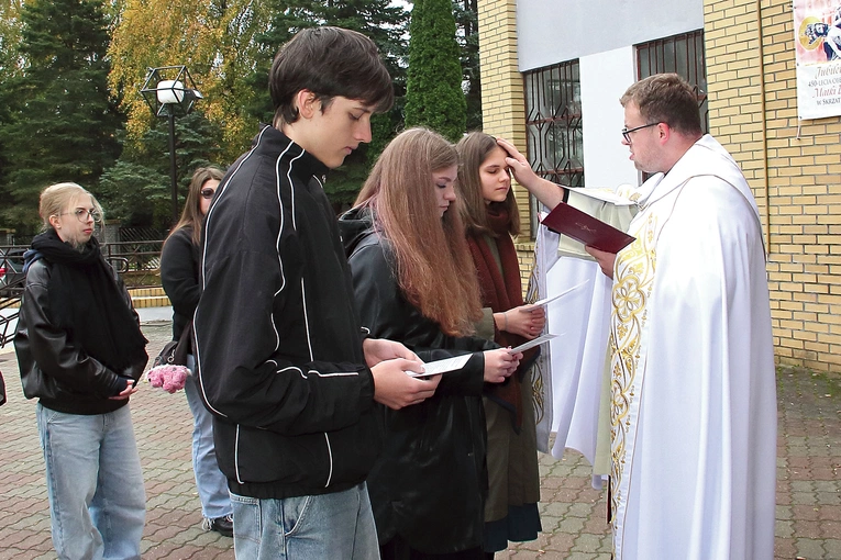 Ks. Pawlak  kreśli krzyż na czołach oazowiczów.