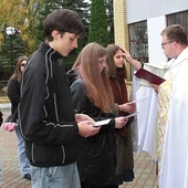 Ks. Pawlak  kreśli krzyż na czołach oazowiczów.