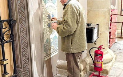 Prof. Sylwester Piędziejewski pracuje przy malowidłach na tylniej ścianie świątyni na Tumskim Wzgórzu.