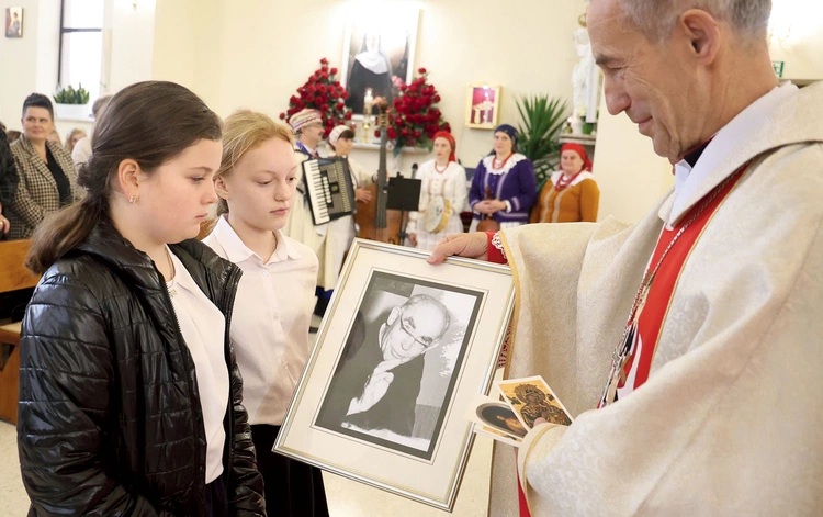 Dzieci ze szkoły w Łękawce w procesji z darami przynoszą zdjęcia ks. Jana Marszałka.