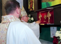 Biskup wraz z proboszczem zainstalowali relikwiarze w specjalnej gablocie.