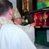 Biskup wraz z proboszczem zainstalowali relikwiarze w specjalnej gablocie.