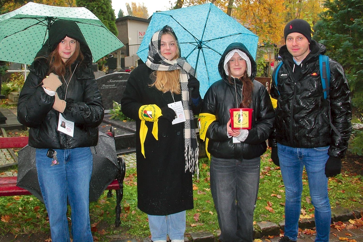 Zuzia, Michalina i Ola z ks. Rafałem kwestują na cmentarzu w Słupsku.