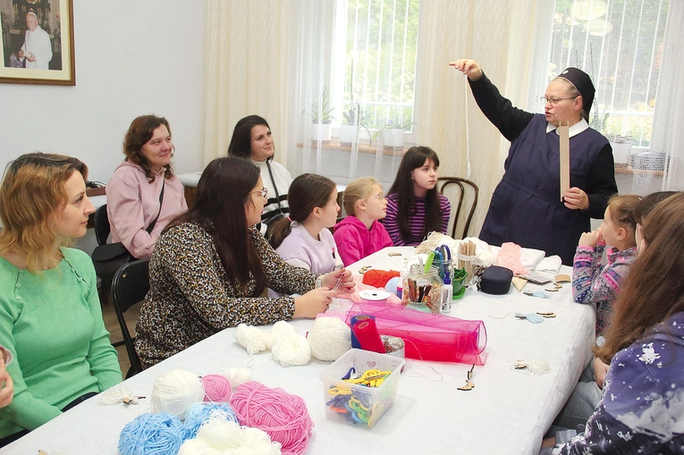 Siostra Michaela instruuje, jak poradzić sobie z włóczką w czasie robienia aniołków. 