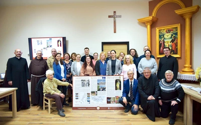  Uczestnicy seminarium z tablicą informacyjną o początku brzeskiego odcinka szlaku do Rzymu.