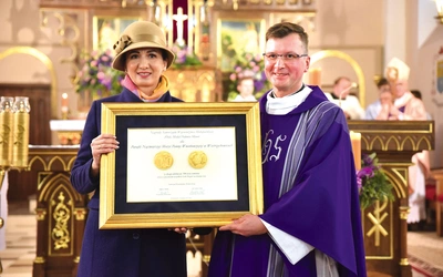 Marta Malec-Lech wręcza medal proboszczowi ks. Jackowi Walczykowi. Wyróżnienie zostało przyznane całej parafii. 