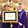 Marta Malec-Lech wręcza medal proboszczowi ks. Jackowi Walczykowi. Wyróżnienie zostało przyznane całej parafii. 