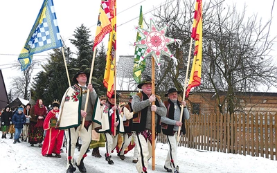 Górale niosą królewskie chorągwie.