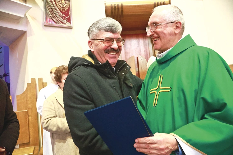 Julian Kozioł odbiera dyplom z rąk o. Ryszarda Żubera OFM.