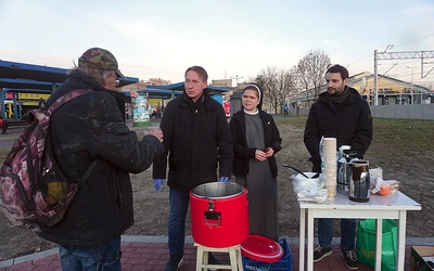 Siostra z pomocnikami podczas rozdawania posiłku na dworcu w Bytomiu.