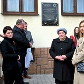 Krewni Augustynów i samorządowcy przed  odsłoniętą tablicą.