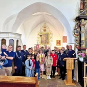 Wspólne zdjęcie ofiarodawczyni ze strażakami i proboszczem.